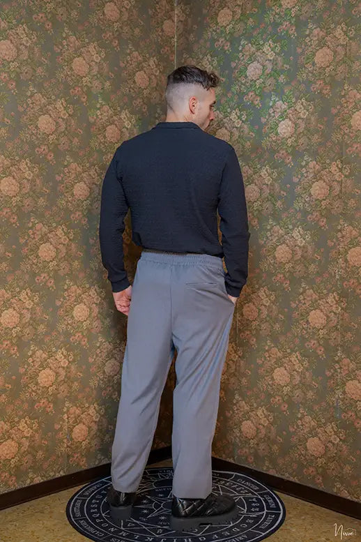 Modello di spalle indossa camicia goffrata nera Takeshy Kurosawa, vista posteriore su sfondo floreale