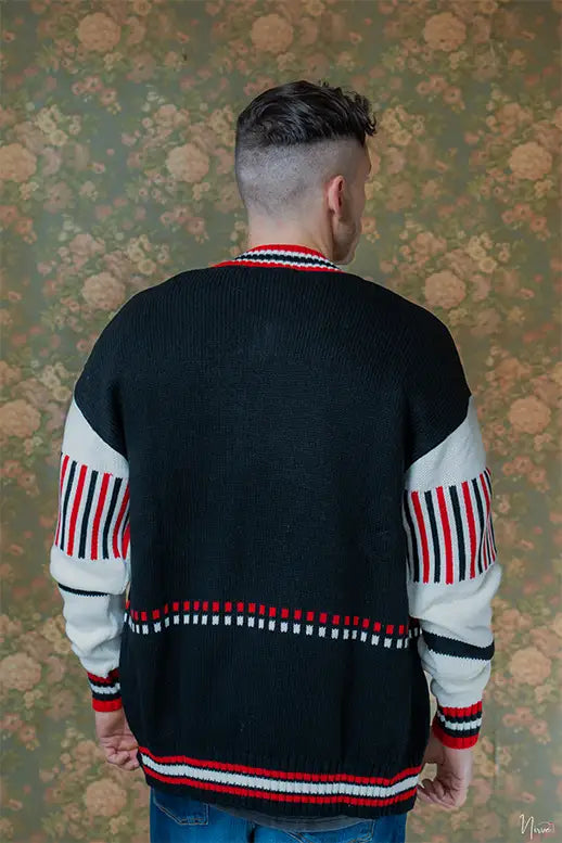 Modello indossa cardigan fullzip LES COSTUMES in acrilico nero con logo jacquard, vista posteriore
