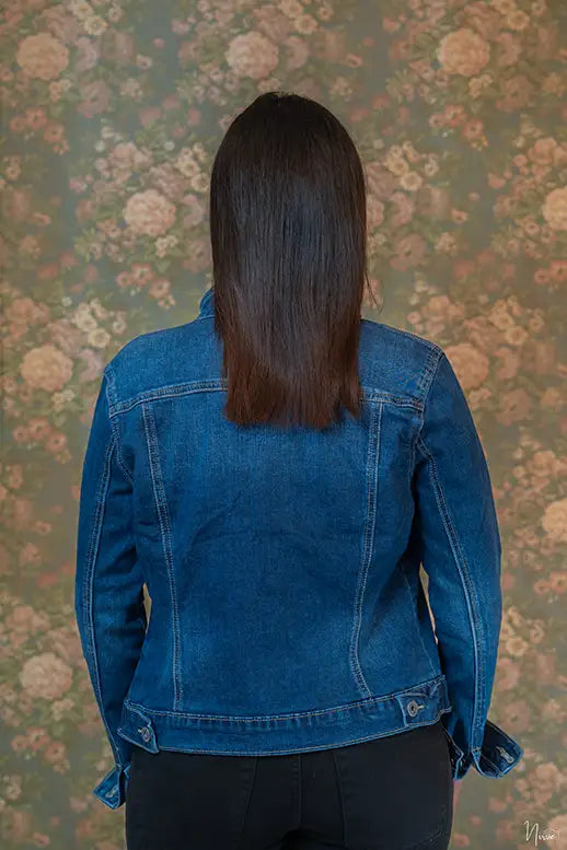 Retro della giacca di jeans COLLISION indossata, dettaglio cuciture e chiusura con bottoni sul fondo.