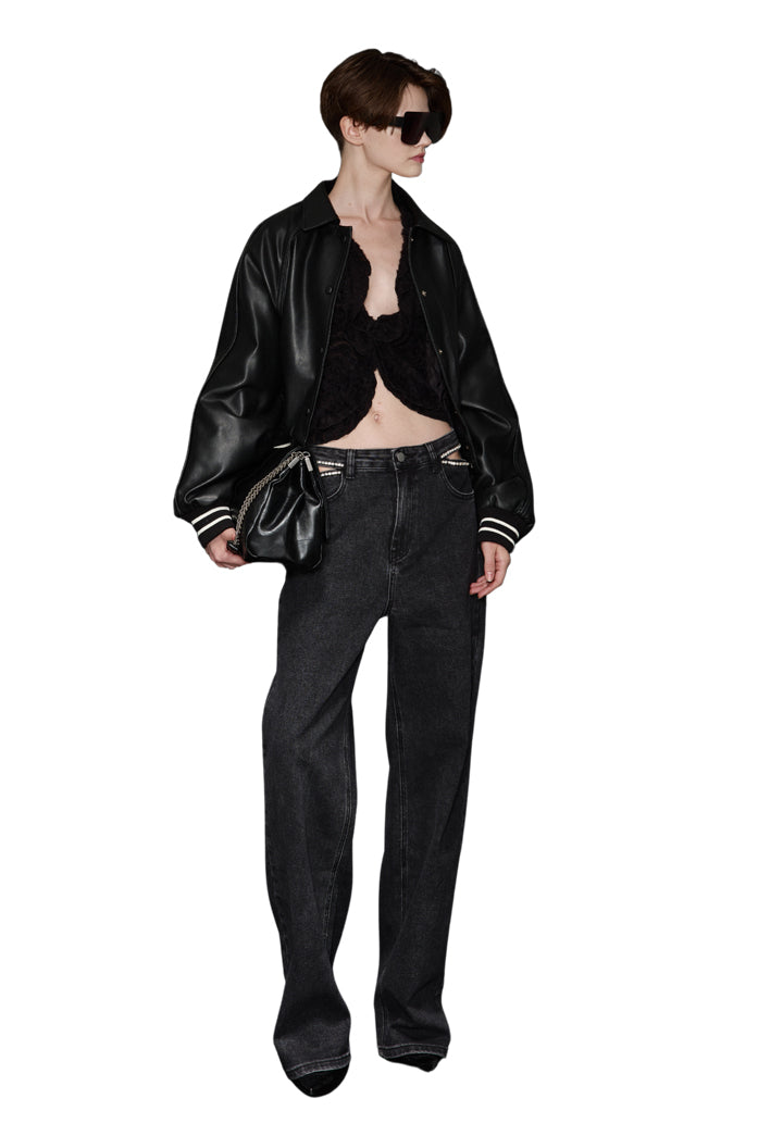 Look urban glam con bomber nero in ecopelle e jeans scuri, stile deciso per la donna moderna