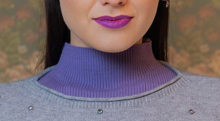 Primo piano del collo alto viola della maglia a costine sotto maglia grigia con dettagli a micro borchie