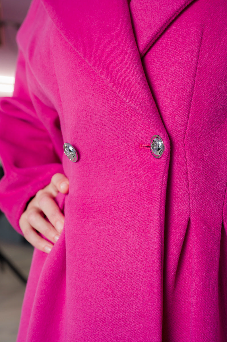 Dettaglio macro dei bottoni lucidi sul cappotto doppio petto fucsia Monique Garçonne