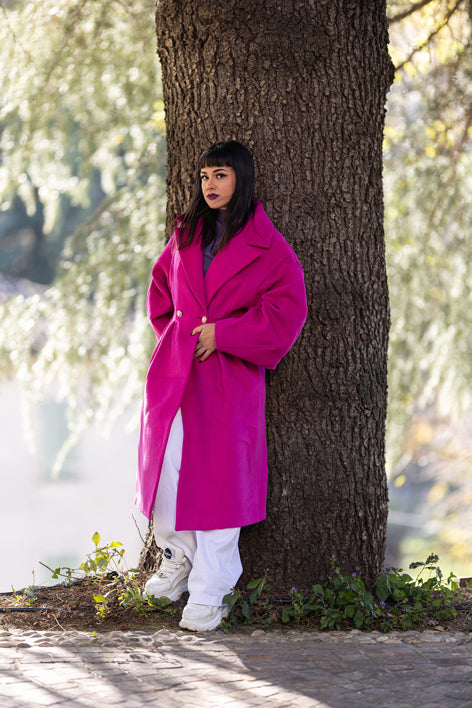 Modella in cappotto lungo fucsia Monique Garçonne in ambiente naturale, look elegante
