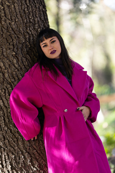 Donna con cappotto doppio petto fucsia Monique Garçonne, trucco strong, scatto outdoor