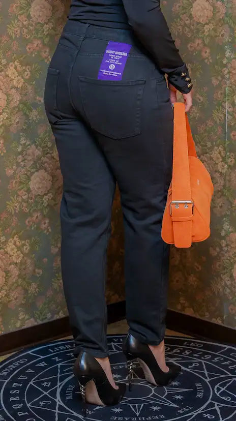 Vista posteriore dei Jeans Denim Bull Over Fit Takeshy Kurosawa con tasche dietro e patch brand viola.