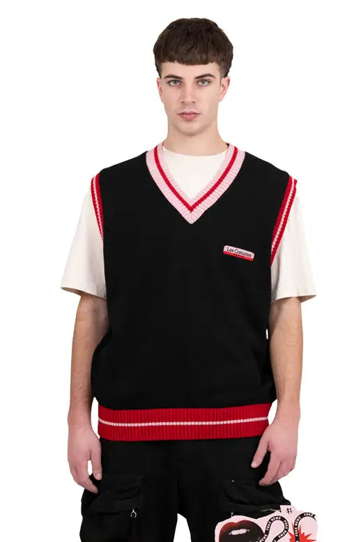 Modello frontale indossa gilet nero in acrilico LES COSTUMES con scollo a V e ricamo a forma di cuore sul petto